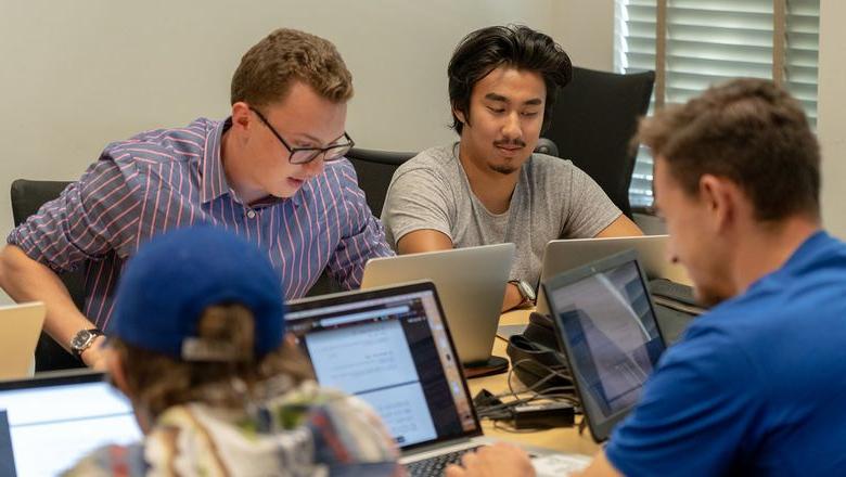 学生 using their laptops to work together on a group project